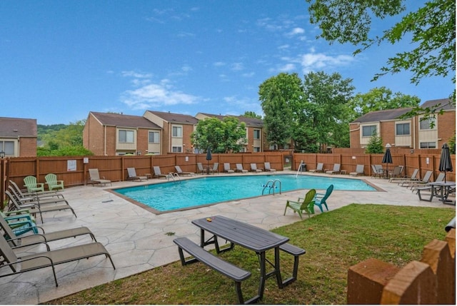 pool with a patio area, a fenced backyard, and a lawn