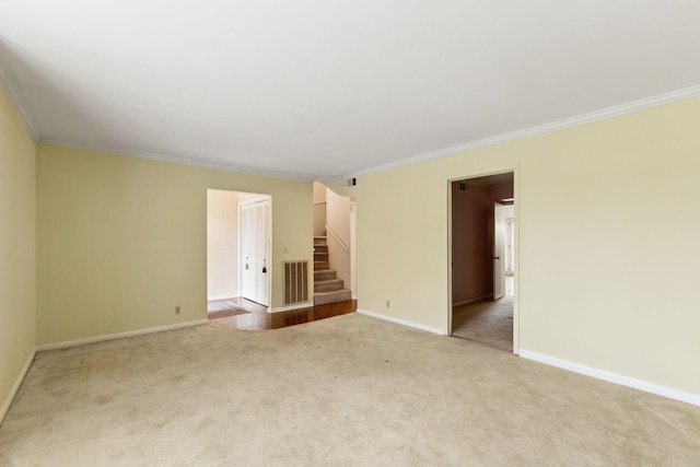 carpeted spare room with ornamental molding, stairway, and baseboards