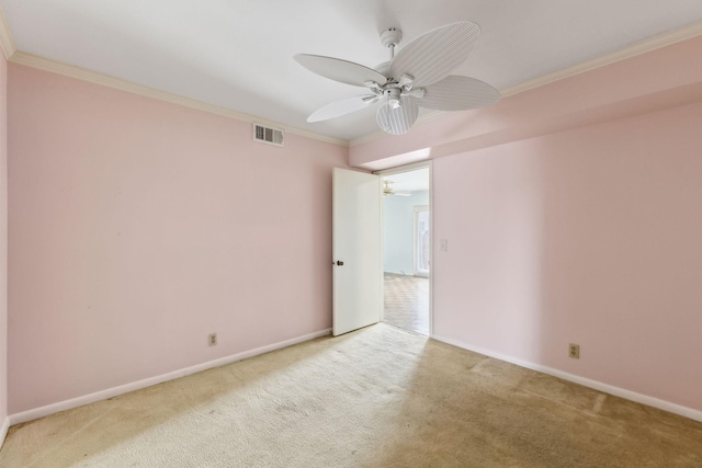 carpeted empty room featuring baseboards, visible vents, ceiling fan, and ornamental molding