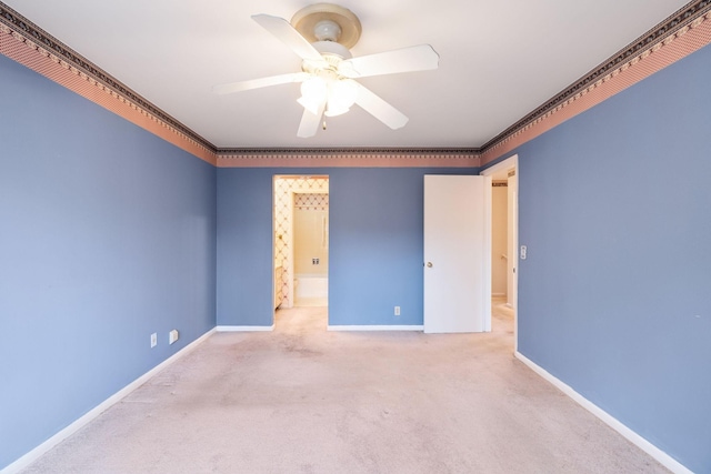 carpeted empty room with ceiling fan, ornamental molding, and baseboards