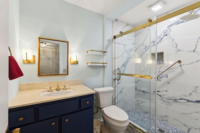 full bath with a marble finish shower, vanity, and toilet