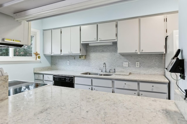 kitchen featuring tasteful backsplash, dishwasher, light stone counters, and a sink