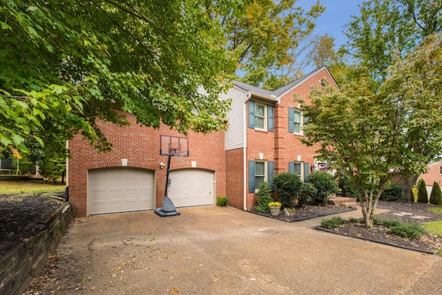 colonial-style house with a garage, driveway, and brick siding