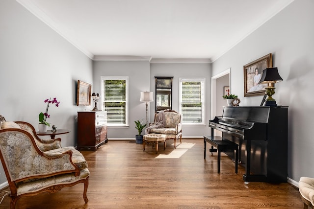 living area featuring crown molding, wood finished floors, and baseboards