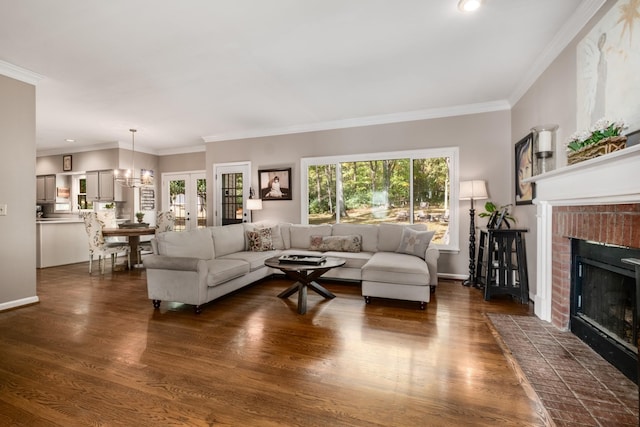 living area with baseboards, a fireplace, ornamental molding, and dark wood-style flooring