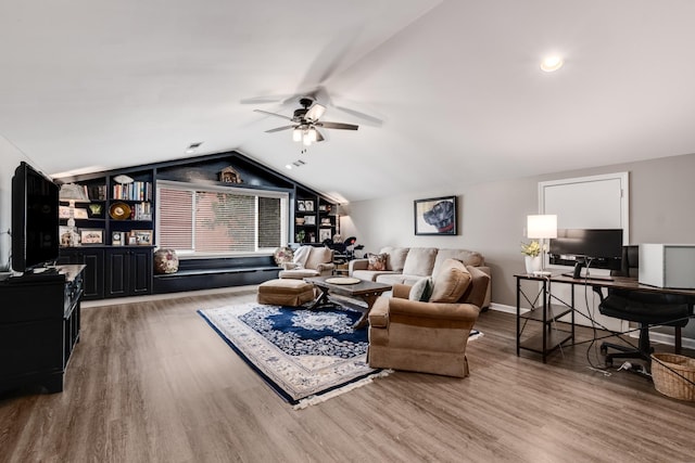 living area featuring a ceiling fan, vaulted ceiling, and wood finished floors