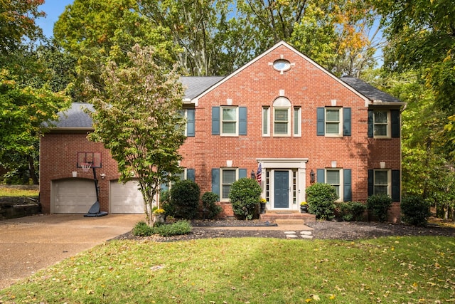 colonial-style house featuring an attached garage, brick siding, a shingled roof, concrete driveway, and a front lawn