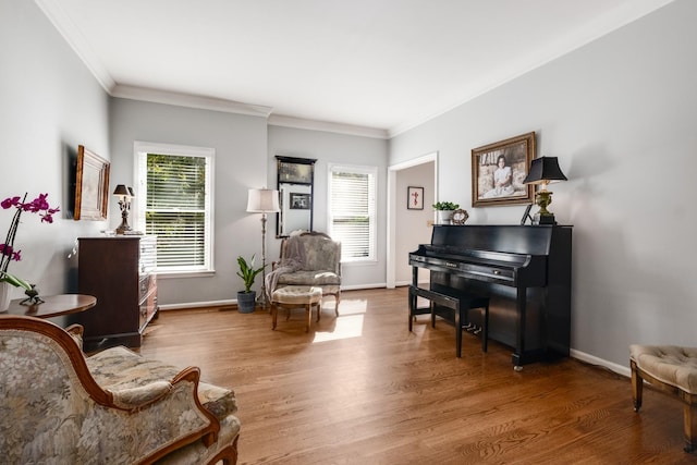 living area with a wealth of natural light, baseboards, and wood finished floors