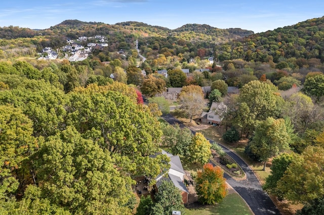 drone / aerial view featuring a wooded view and a mountain view