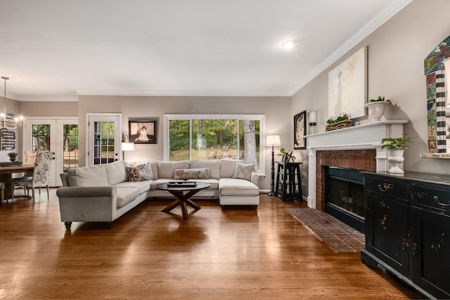 living area with a fireplace, wood finished floors, and crown molding