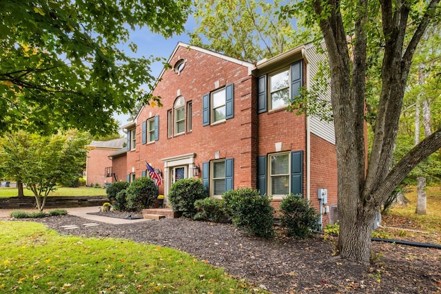 colonial inspired home featuring brick siding