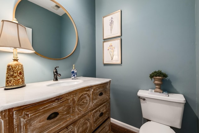 bathroom featuring toilet, visible vents, baseboards, and vanity