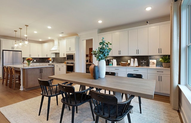 dining space with recessed lighting and light wood-style flooring