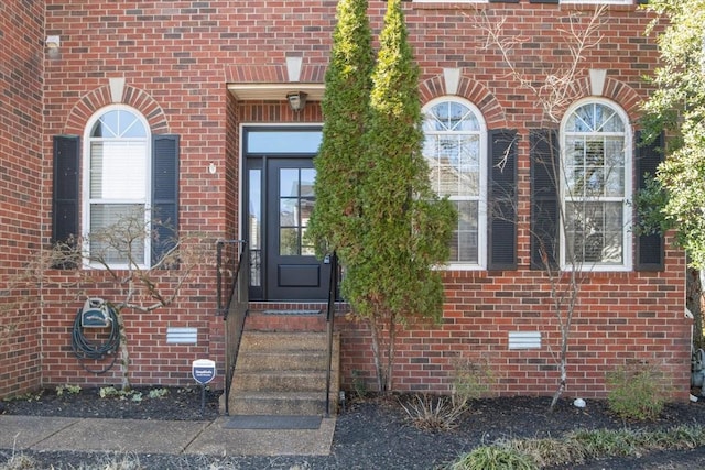 property entrance featuring brick siding