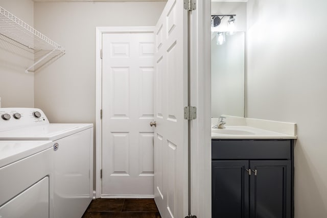 clothes washing area with a sink, washing machine and clothes dryer, and cabinet space