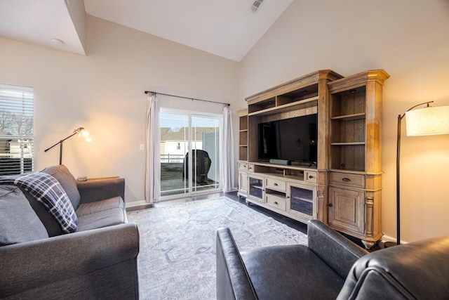 living area with high vaulted ceiling and baseboards