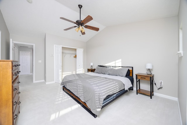 bedroom with a closet, light carpet, vaulted ceiling, and baseboards