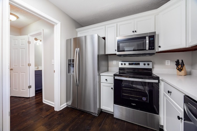 kitchen with dark wood-style flooring, stainless steel appliances, a textured ceiling, light countertops, and white cabinetry