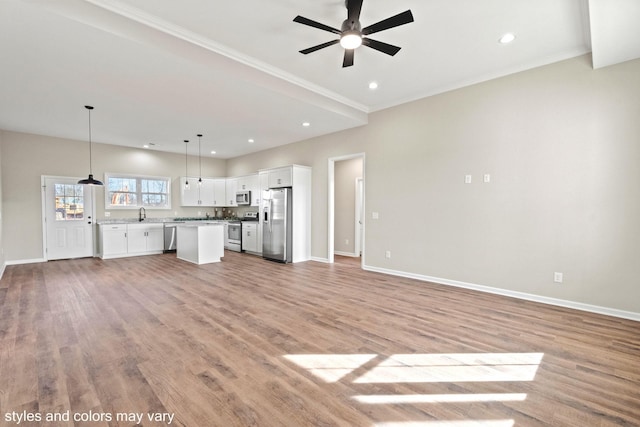 unfurnished living room with recessed lighting, light wood-style floors, a sink, ceiling fan, and baseboards