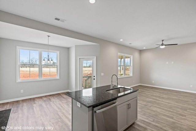 kitchen with light wood finished floors, visible vents, dishwasher, open floor plan, and a sink