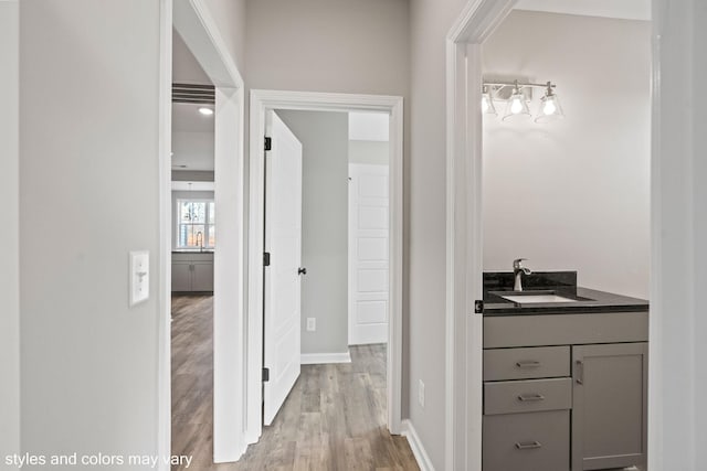 bathroom with baseboards, wood finished floors, and vanity