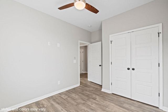 unfurnished bedroom featuring a closet, ceiling fan, baseboards, and wood finished floors