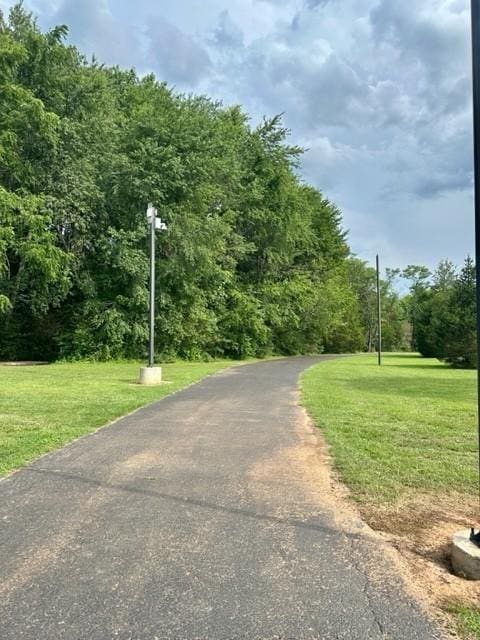 view of community featuring a yard and aphalt driveway