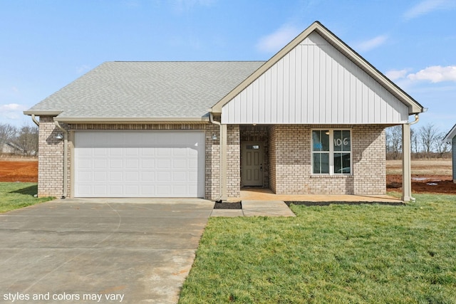 view of front facade with driveway, brick siding, an attached garage, and a front yard