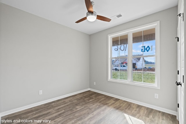 empty room with visible vents, baseboards, ceiling fan, and wood finished floors