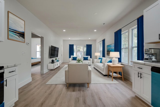 living area with light wood-style floors, baseboards, and recessed lighting