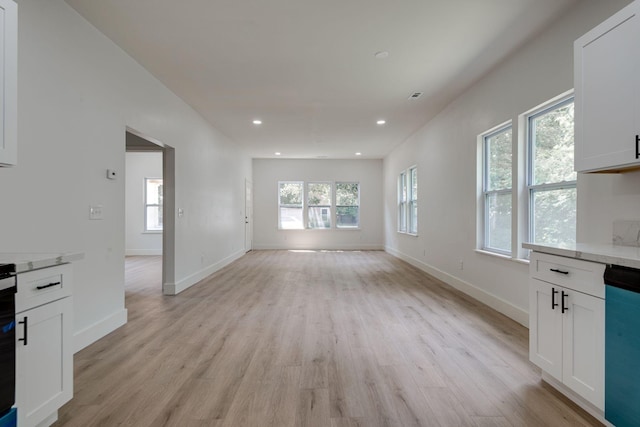 unfurnished living room featuring baseboards, recessed lighting, and light wood-style floors