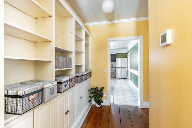 interior space with baseboards, dark wood-type flooring, and crown molding