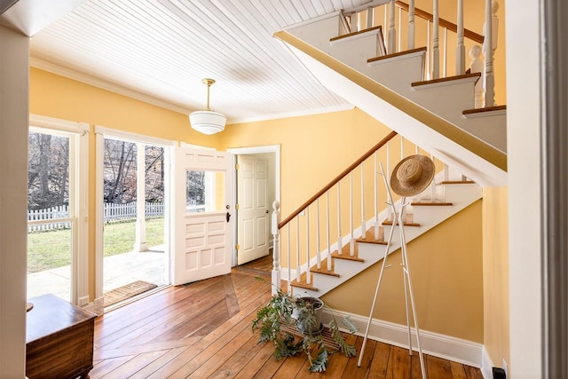 entryway with baseboards, stairway, hardwood / wood-style flooring, and crown molding