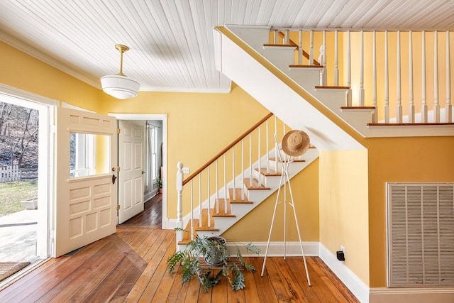 entryway featuring ornamental molding, baseboards, hardwood / wood-style floors, and stairs