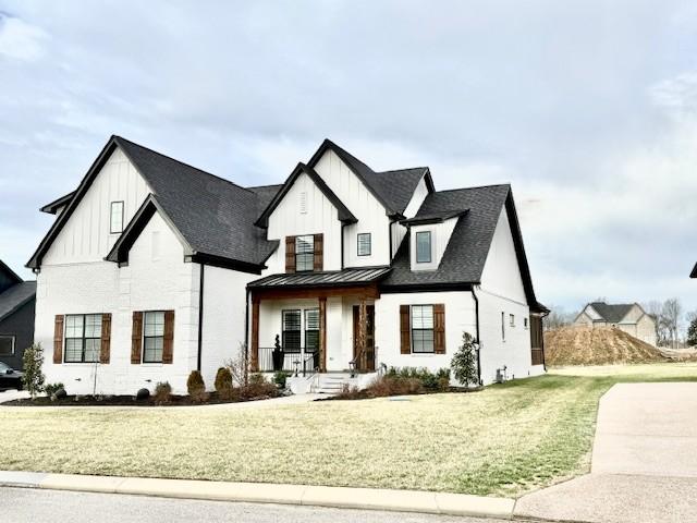 modern farmhouse with a standing seam roof, metal roof, a front lawn, and board and batten siding