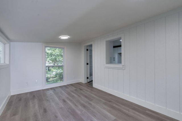 unfurnished room with baseboards and wood finished floors