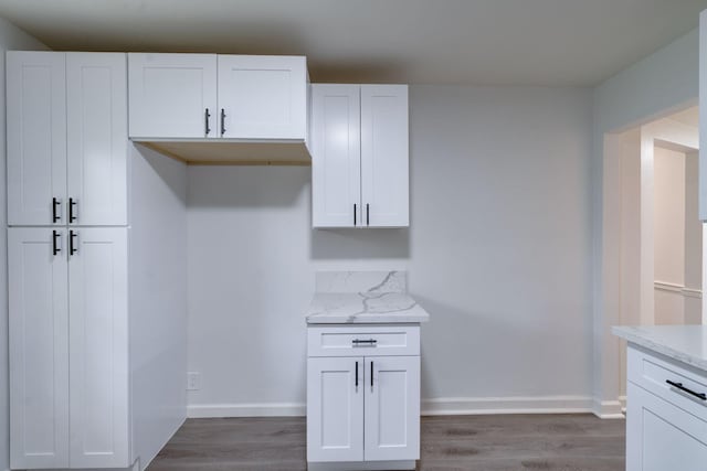 kitchen featuring light stone counters, white cabinetry, and dark wood finished floors