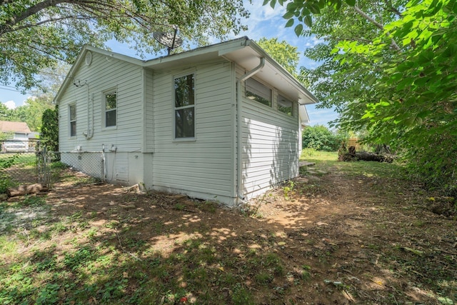 view of side of home featuring fence