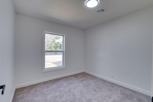 carpeted spare room with baseboards and visible vents