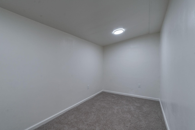 carpeted empty room featuring baseboards