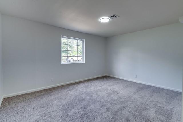 carpeted empty room featuring visible vents and baseboards