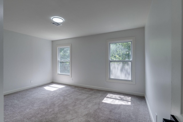 carpeted spare room with baseboards and visible vents