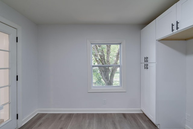 unfurnished room featuring baseboards and light wood-style floors