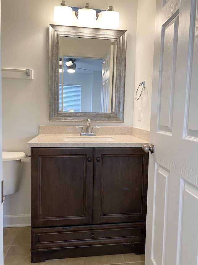 bathroom with toilet, vanity, and tile patterned floors