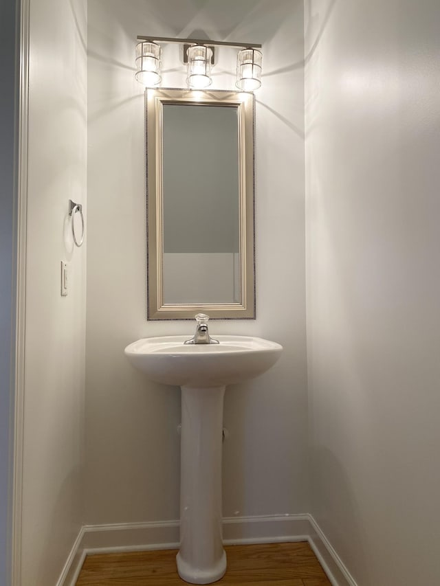 bathroom with wood finished floors and baseboards