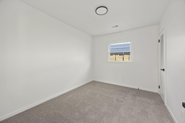 carpeted empty room featuring visible vents and baseboards