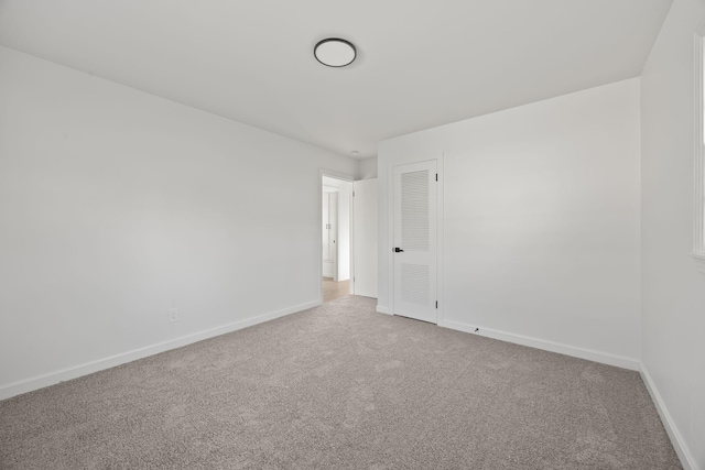 unfurnished room featuring carpet and baseboards