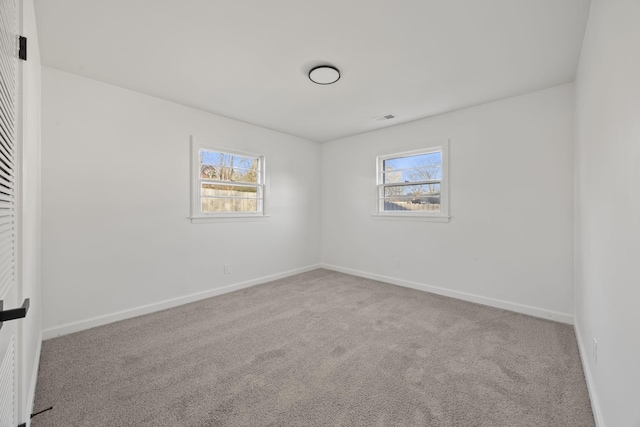 empty room featuring carpet, plenty of natural light, and baseboards