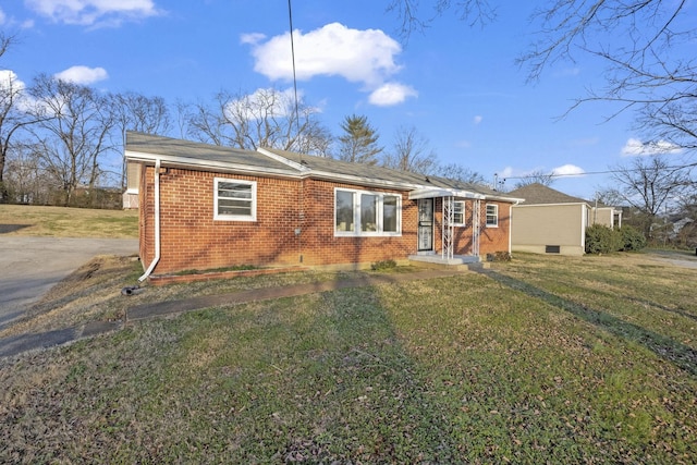 view of front of home with brick siding and a front lawn