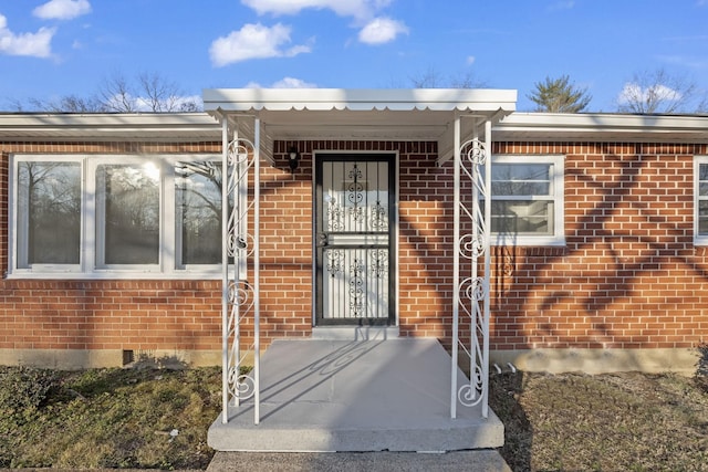 view of exterior entry with brick siding